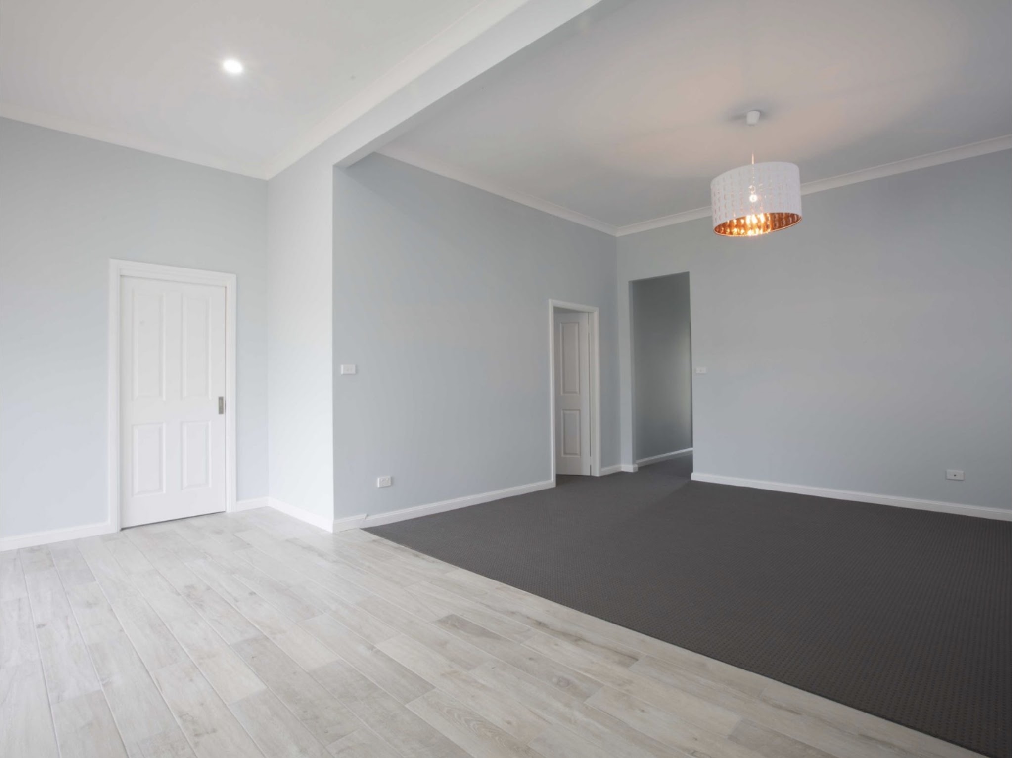 Living and dining room with pale grey walls and white doors and skirting